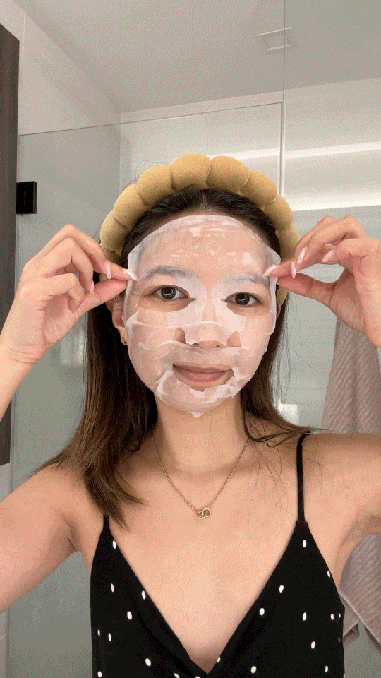 Asian Woman removing snail mask in bathroom