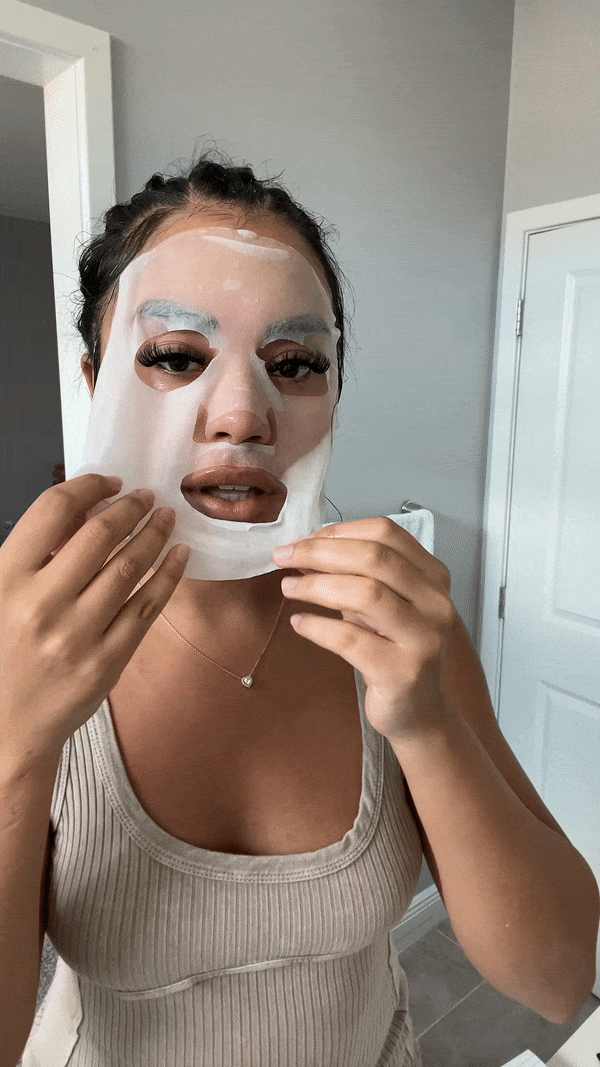 Woman putting on snail mask in bathroom